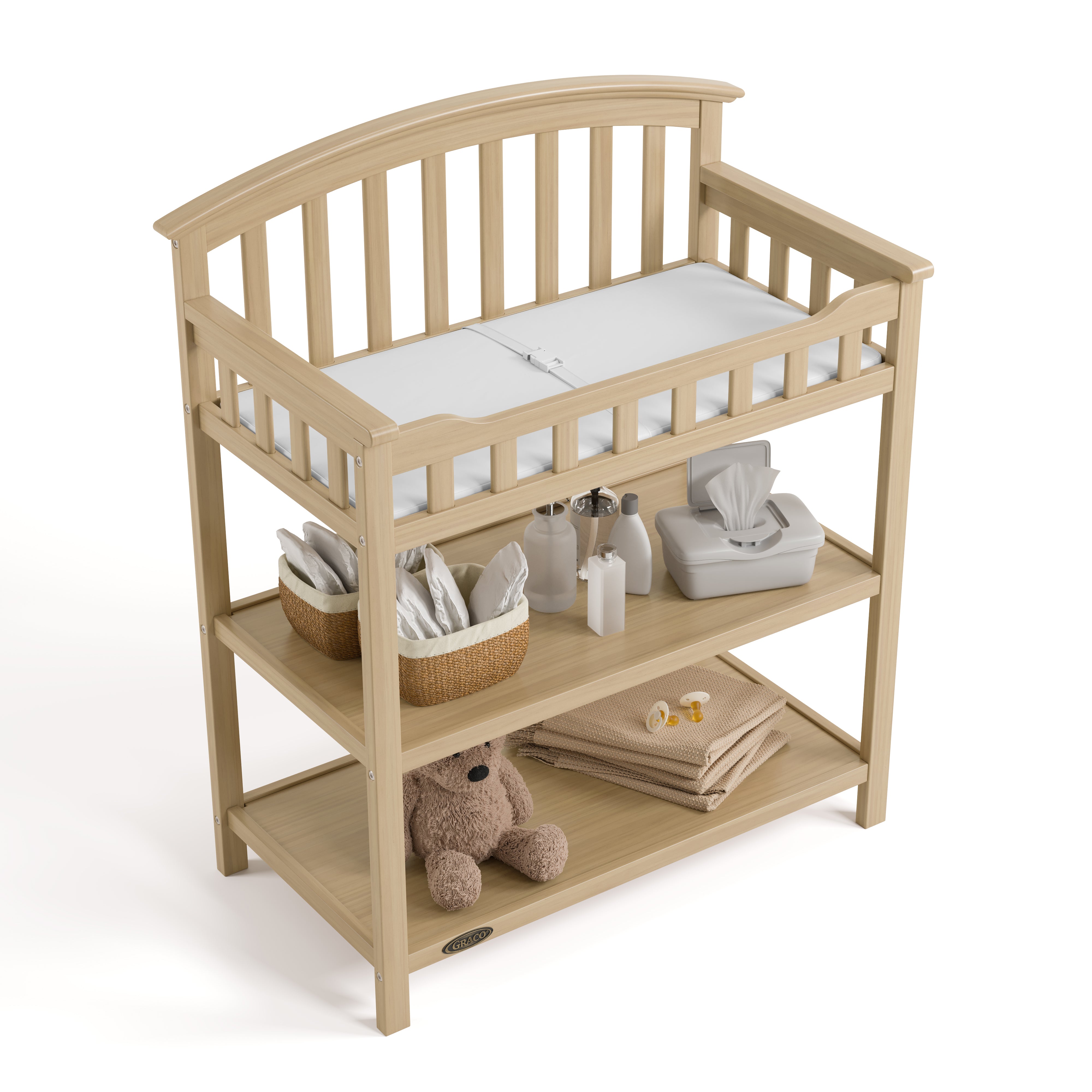 Graco driftwood changing table top view with baby items on bottom shelves