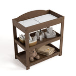 Graco hazelnut customizable changing table top view with baby items on bottom shelves