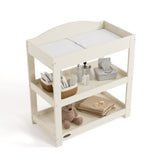 Graco frosted oat customizable changing table top view with baby items on bottom shelves