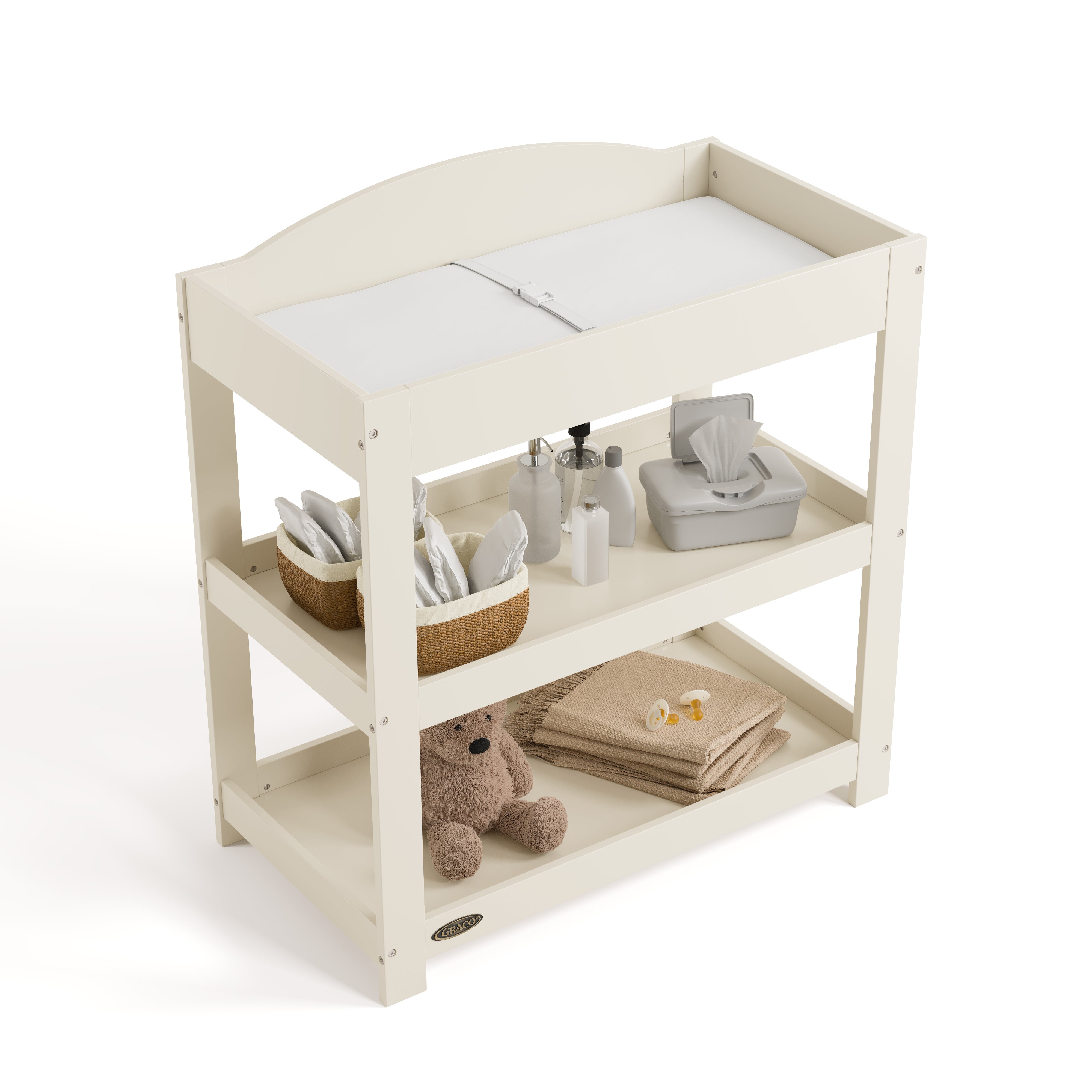 Graco frosted oat customizable changing table top view with baby items on bottom shelves