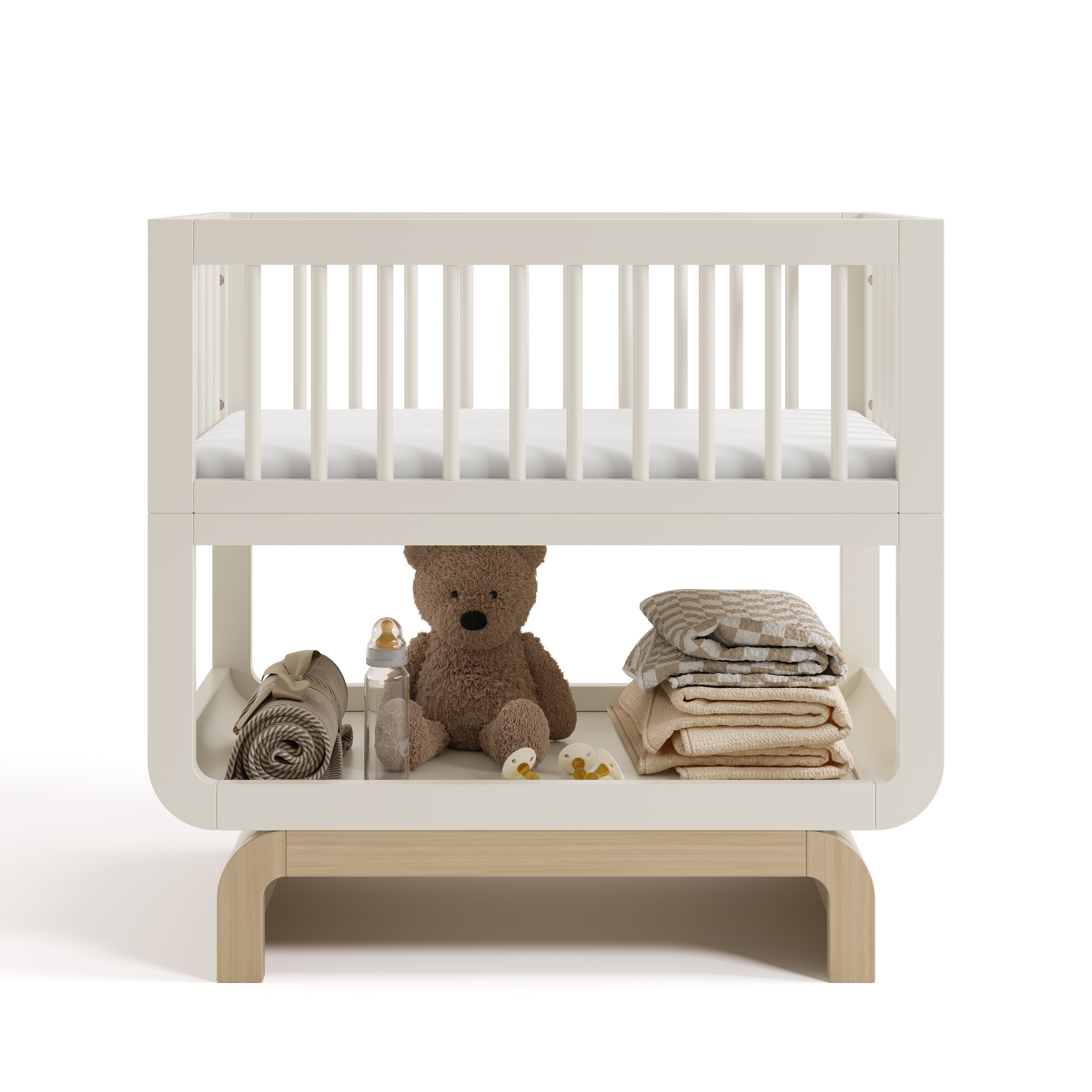 Santorini frosted oat with driftwood bassinet front view with baby items on bottom shelf