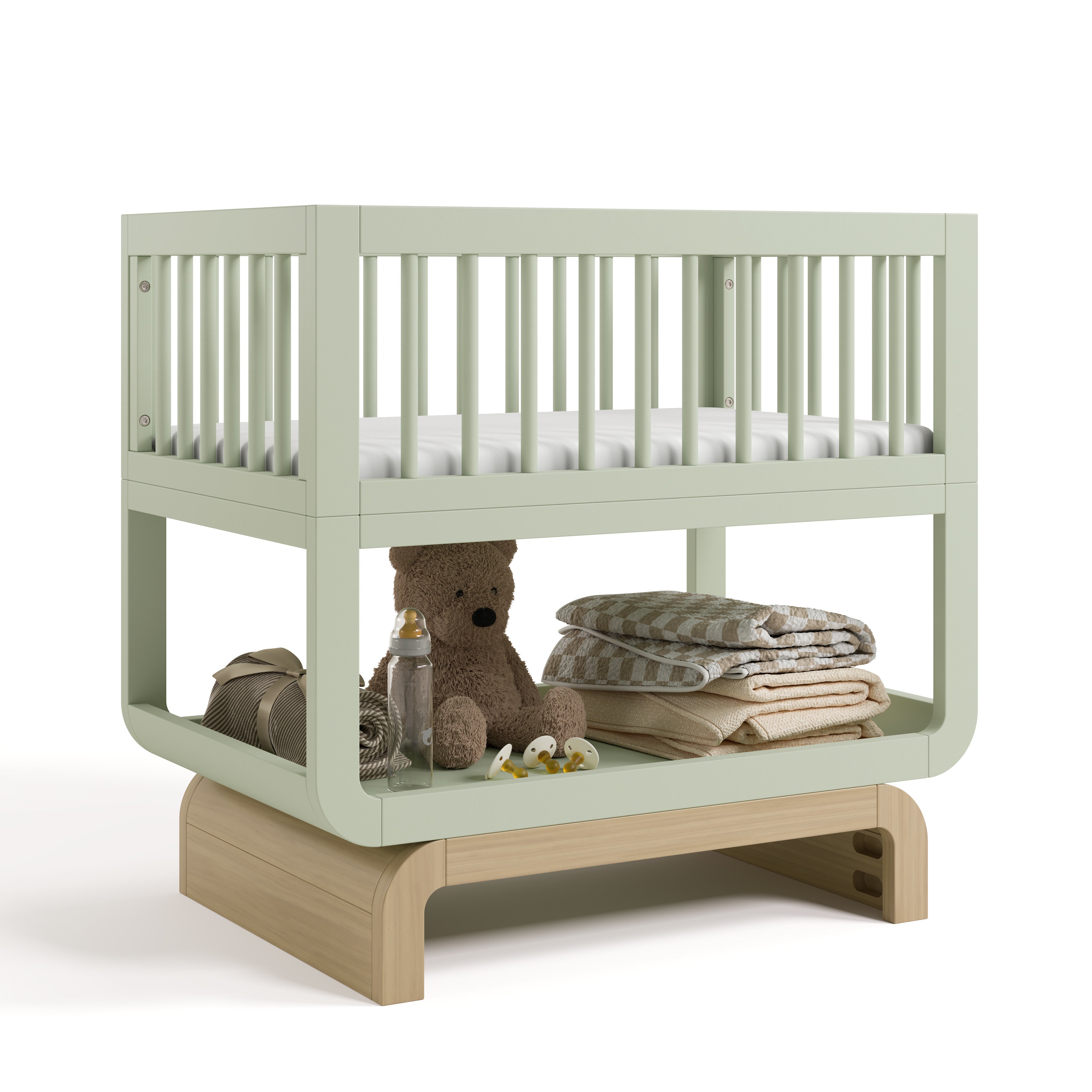 Santorini sage with driftwood bassinet angle view with baby items on bottom shelf