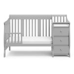 Pebble gray crib in toddler bed conversion with one safety guardrail