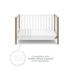 White crib with driftwood in toddler bed conversion with one safety guardrail graphic