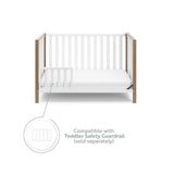 White crib with driftwood in toddler bed conversion with one safety guardrail graphic