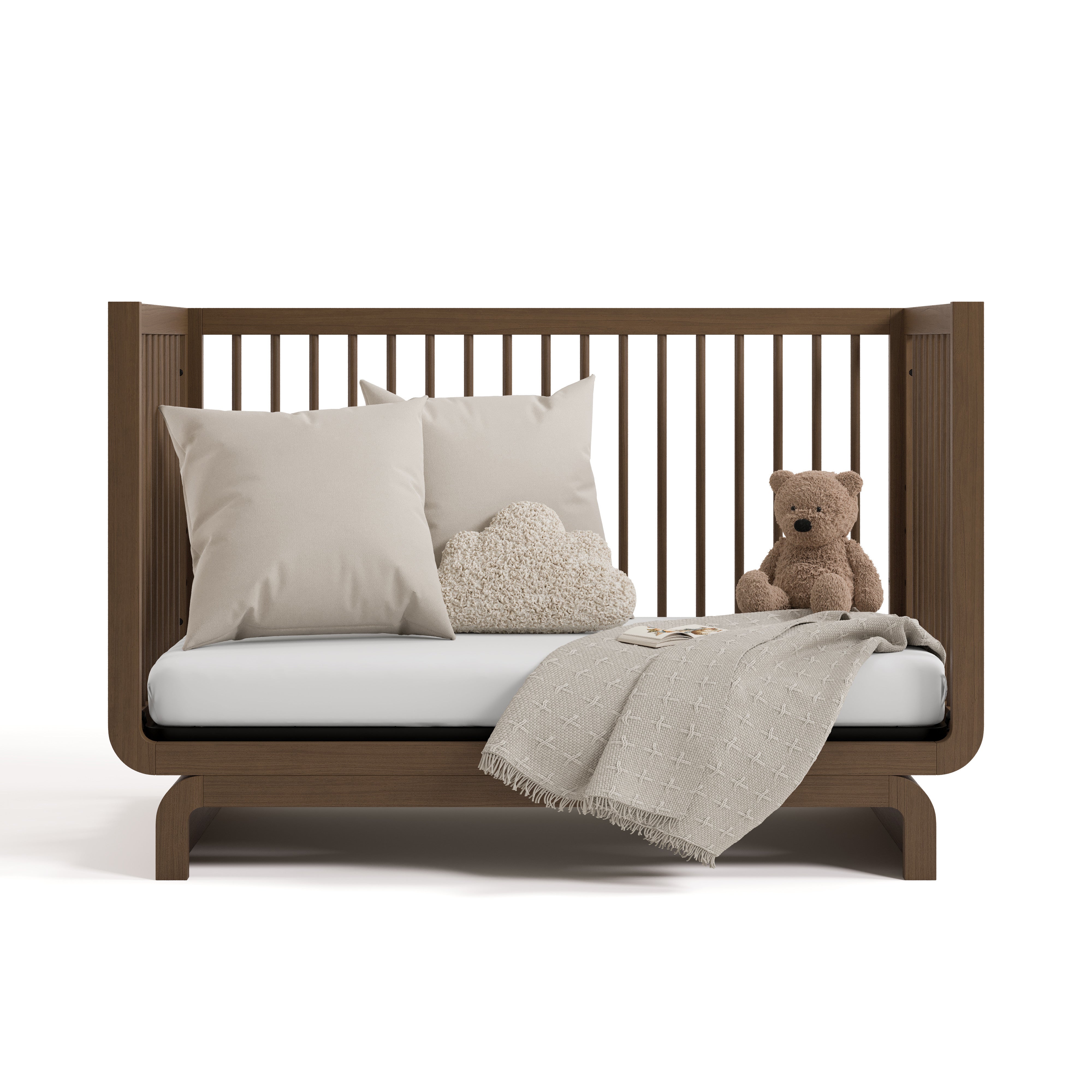 santorini hazelnut crib daybed conversion with blanket, pillows, and teddy bear