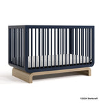 Santorini midnight blue with driftwood crib with 2024 Storkcraft copyright on bottom right