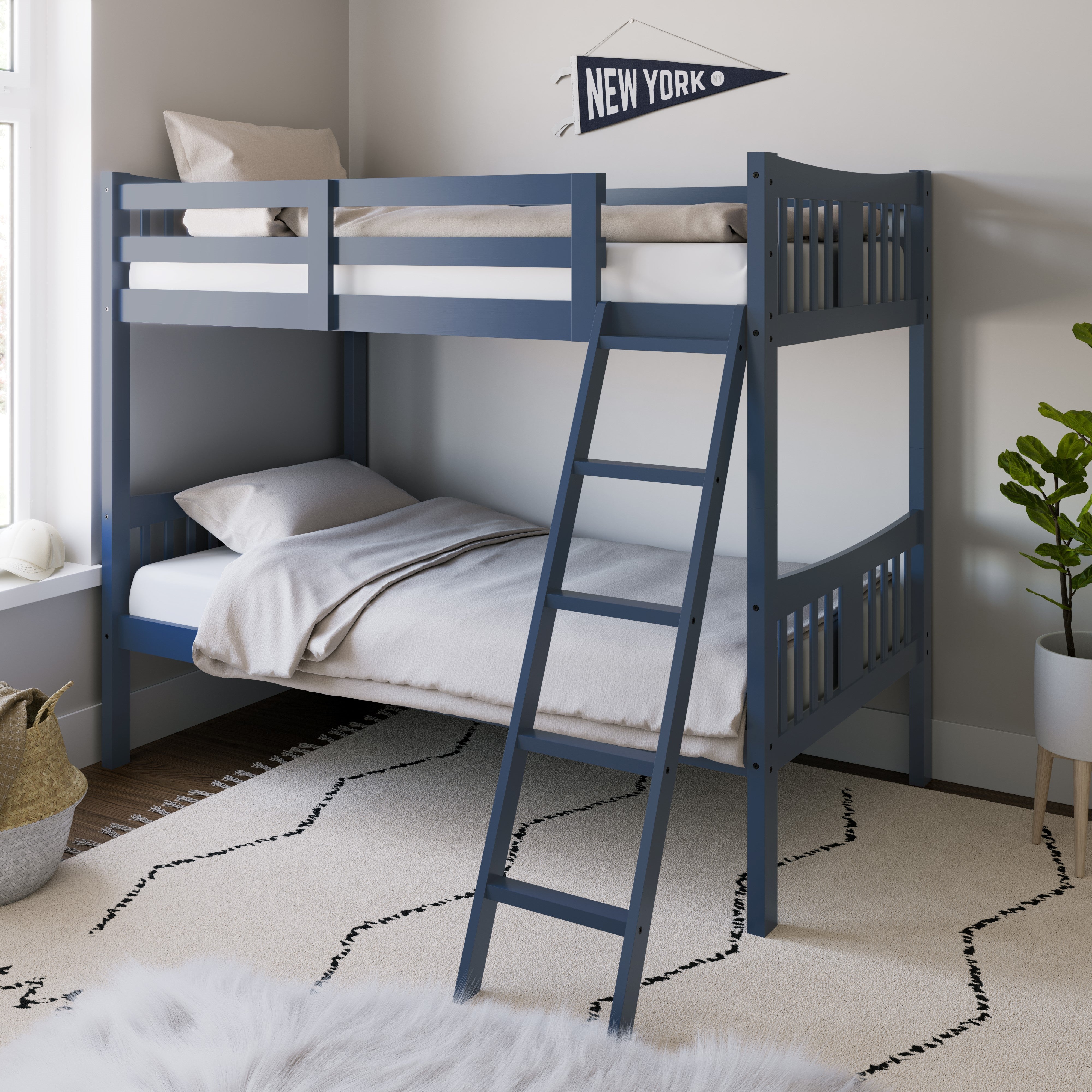 navy bunk bed with fixed ladder angled with bedding in a nursery