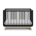 Two-tone black and natural wood baby crib, at a front-facing angle