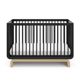 Two-tone black and natural wood baby crib, at a front-facing angle