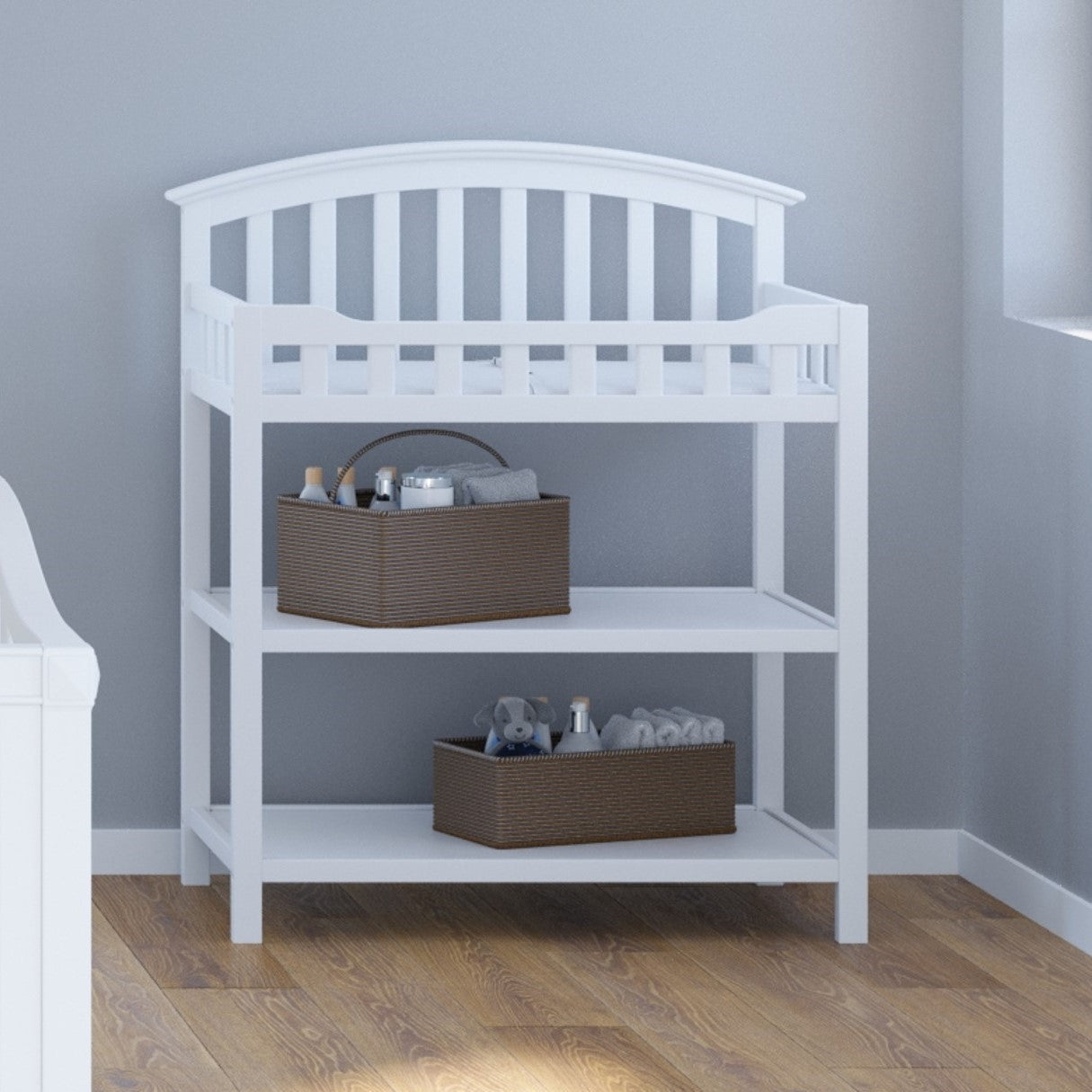 White changing table with two open shelves in nursery
