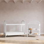 Olivia white changing table in a nursery next to crib
