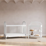 Olivia white changing table in a nursery next to crib