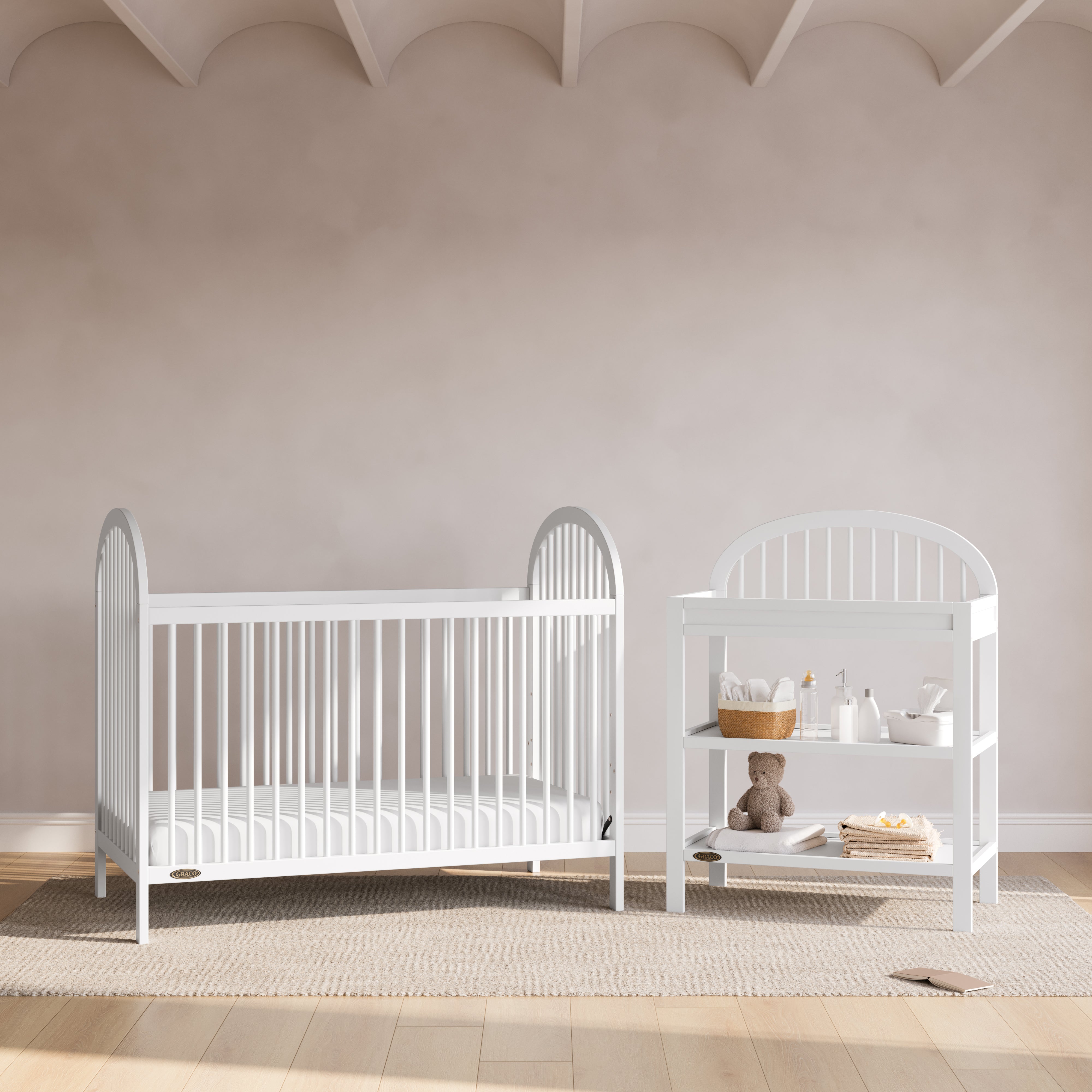 Olivia white changing table in a nursery next to crib