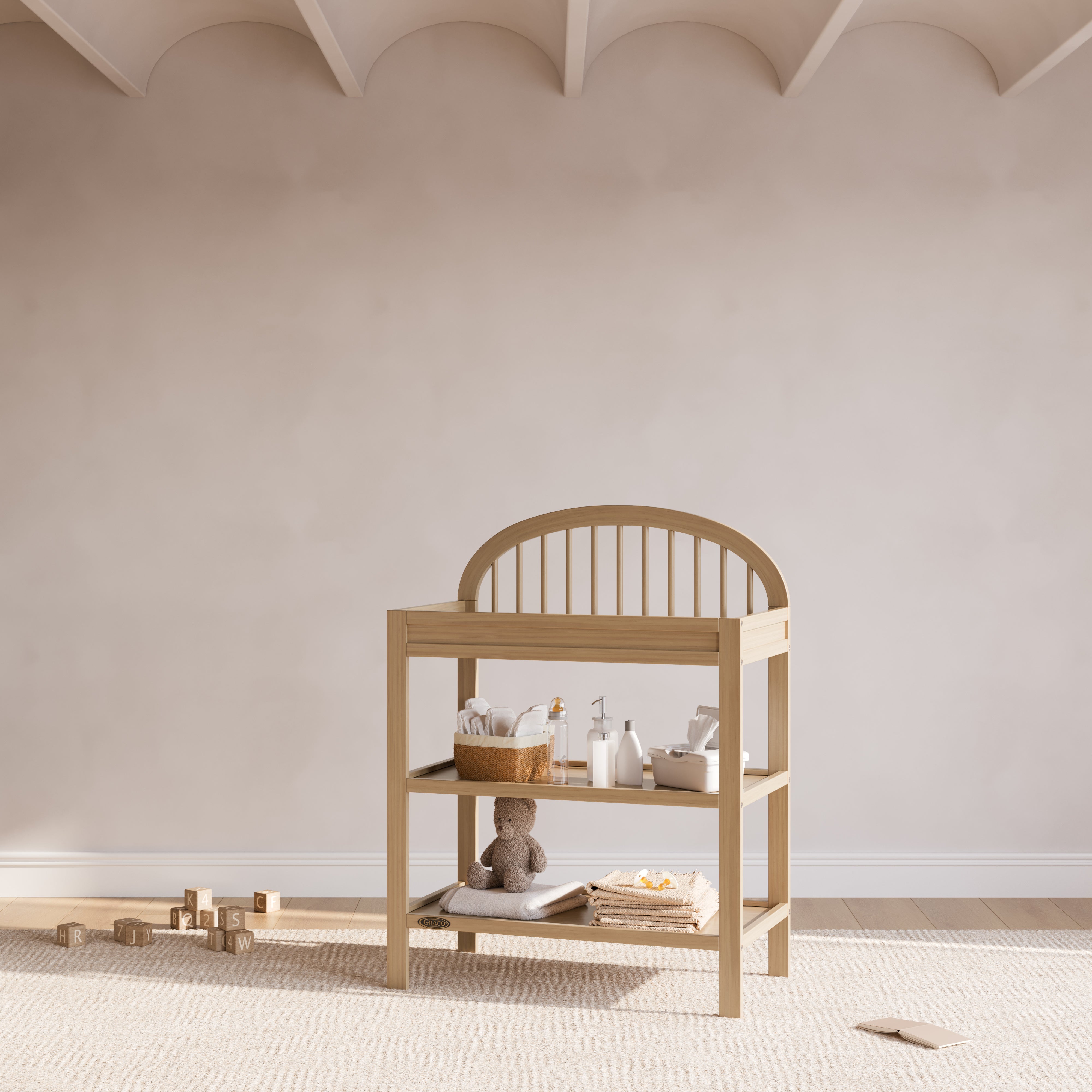 Olivia driftwood changing table in a nursery next to crib