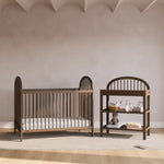 Olivia hazelnut changing table in a nursery next to crib