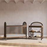 Olivia hazelnut changing table in a nursery next to crib