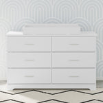 white changing topper on top of 6 drawer dresser in nursery