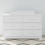 white changing topper on top of 6 drawer dresser in nursery