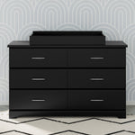 black changing topper on top of 6 drawer dresser in nursery