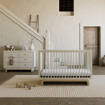 Santorini frosted oat with driftwood 6 drawer dresser in a nursery next to crib