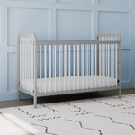 Front view of white crib with pebble gray in nursery