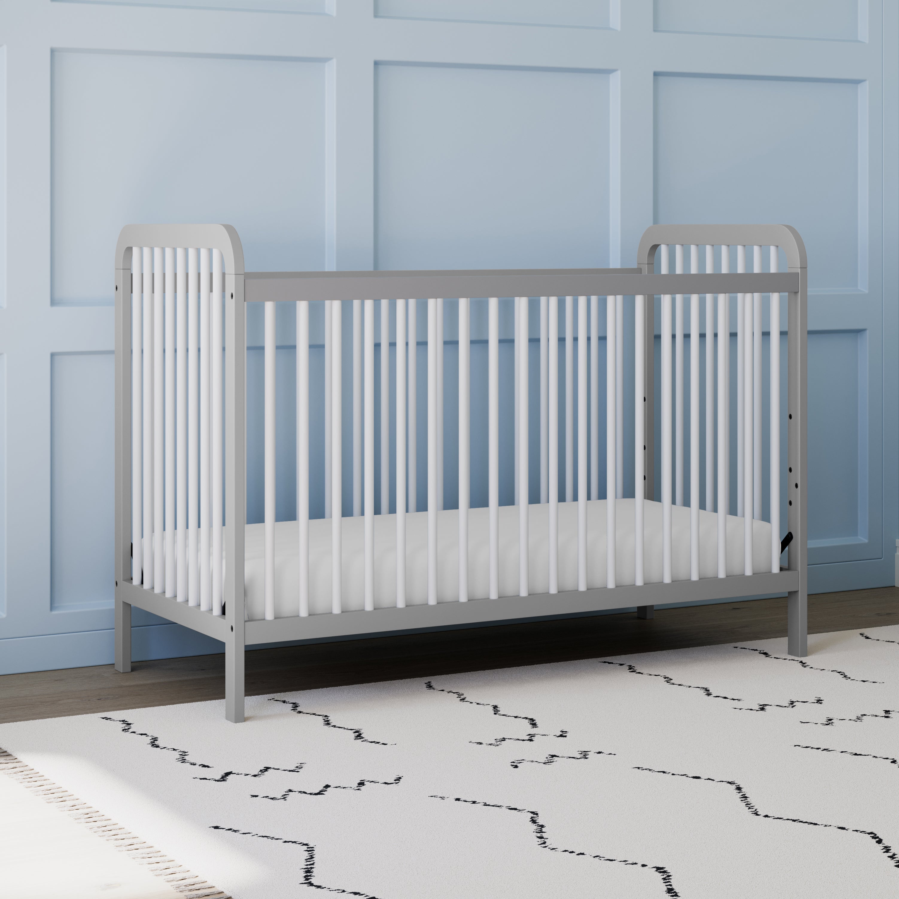 Front view of white crib with pebble gray in nursery