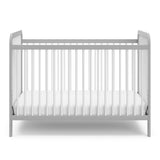 Front view of white crib with pebble gray