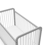 Close-up view of white with pebble gray crib's headboard