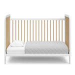 White crib with driftwood in toddler bed conversion