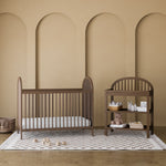 Olivia hazelnut changing table in a nursery next to crib