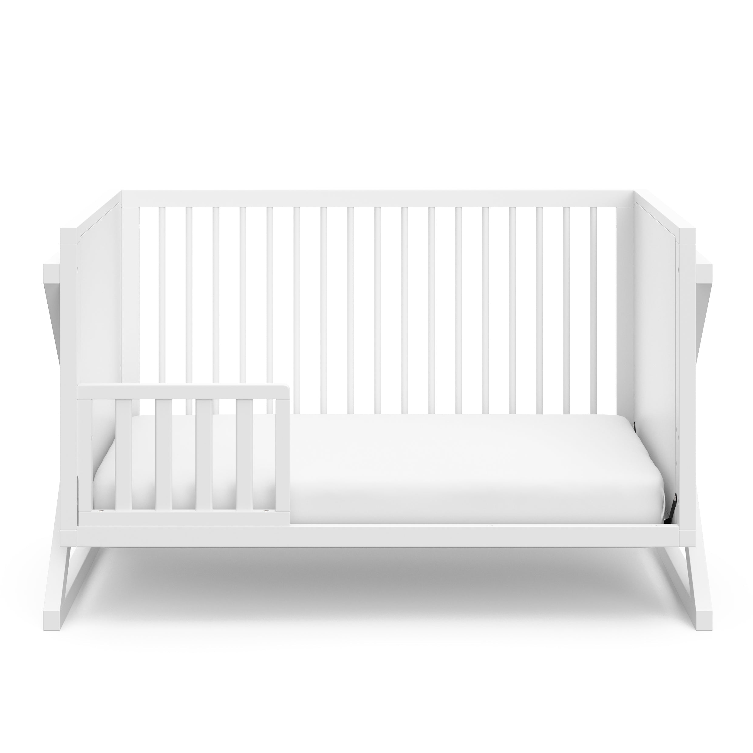 White crib in toddler bed conversion with one safety guardrail