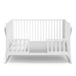 White crib in toddler bed conversion with two safety guardrails