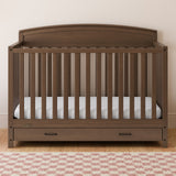 Benton hazelnut crib with drawer in a nursery