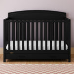 Benton black crib with drawer in a nursery