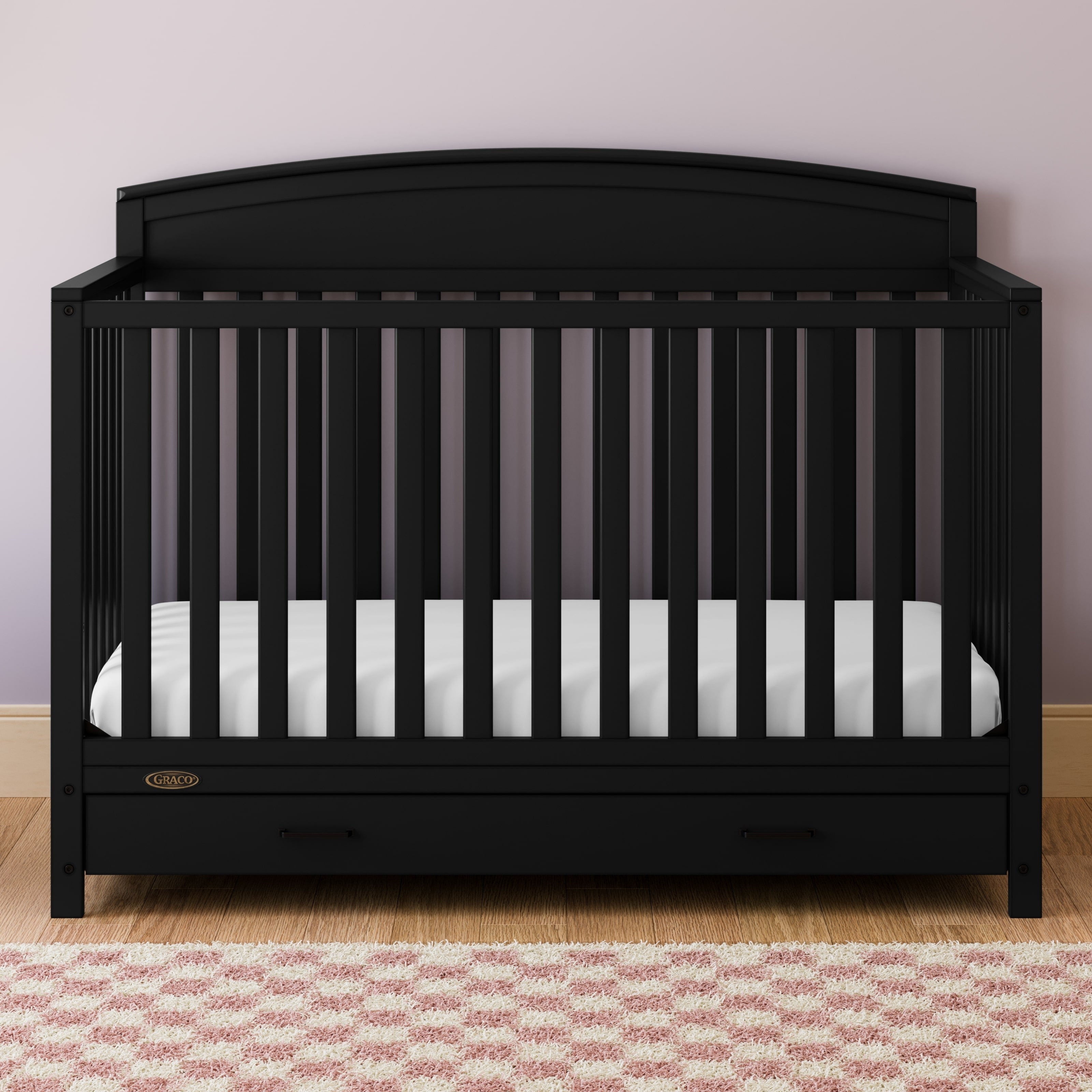 Benton black crib with drawer in a nursery