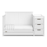 White crib and changer with drawer in toddler bed conversion with one safety guardrail