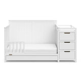 White crib and changer with drawer in toddler bed conversion with one safety guardrail