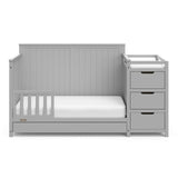 Pebble gray crib and changer with drawer in toddler bed conversion with one safety guardrail
