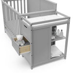Close-up view of Pebble gray crib and changer with open drawer