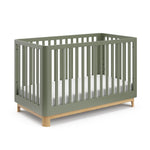 Angled view of an olive crib with a natural wood color base