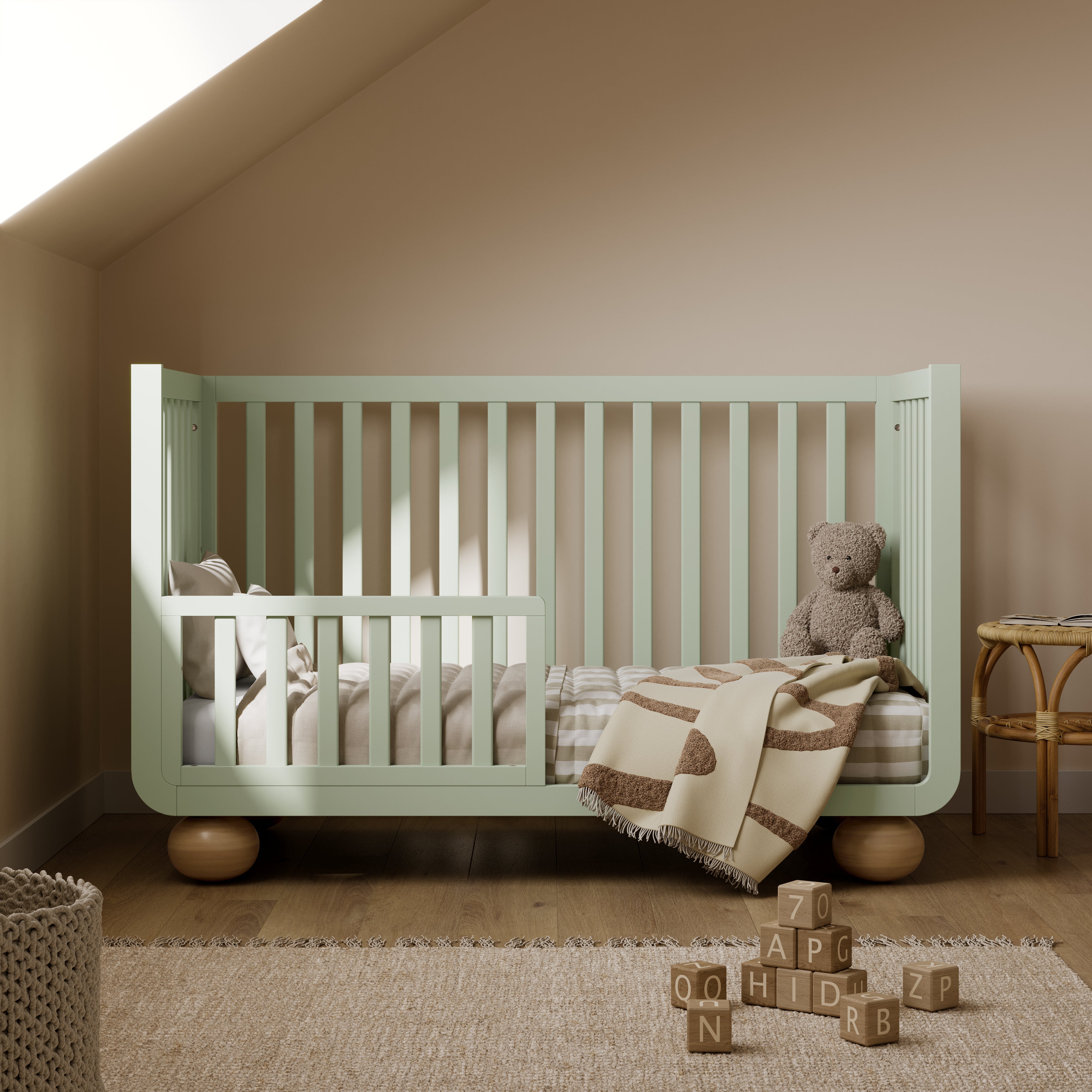 Amalfi sage with driftwood crib converted to toddler bed in a nursery