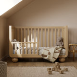 Amalfi driftwood crib converted to toddler bed in a nursery