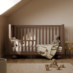 Amalfi hazelnut crib converted to toddler bed in a nursery
