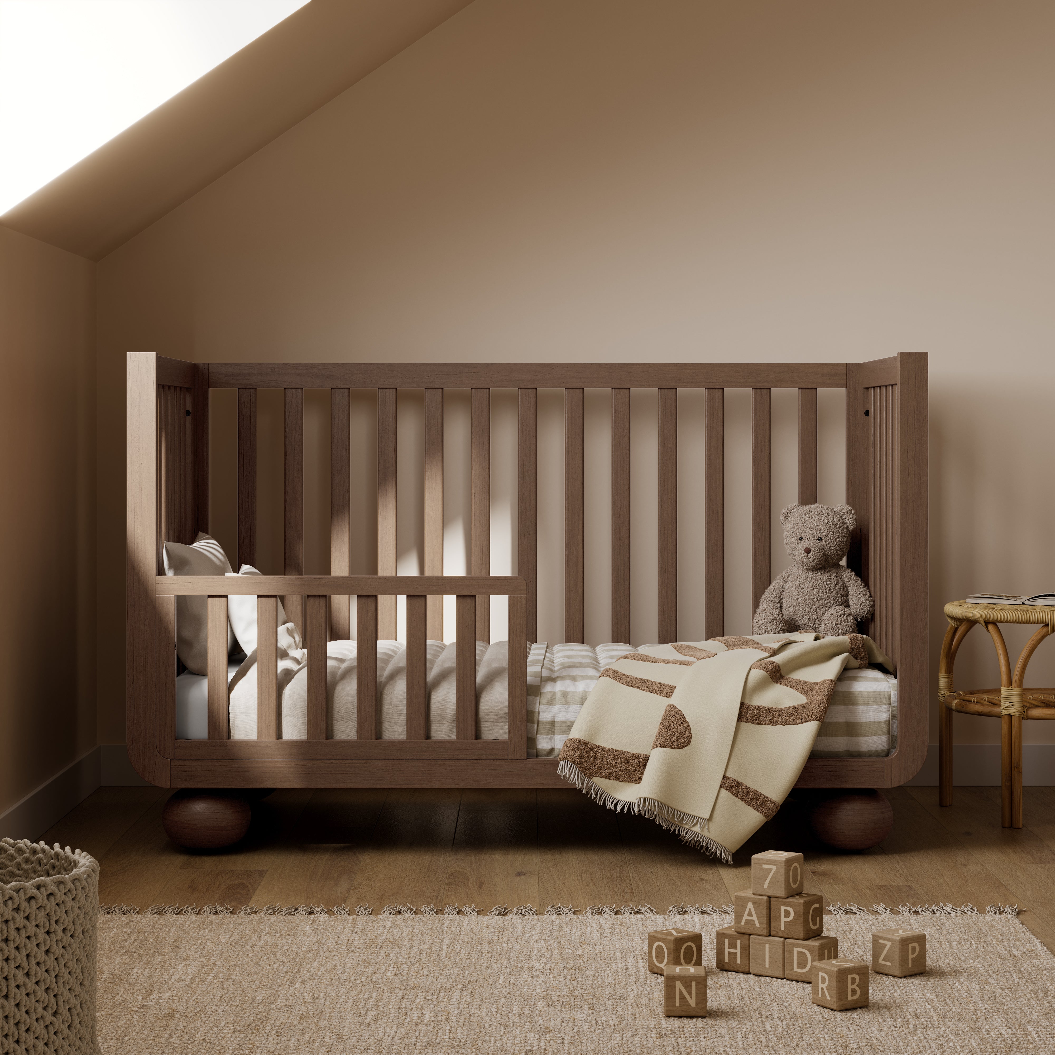Amalfi hazelnut crib converted to toddler bed in a nursery