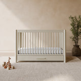 Malta frosted oat crib with drawer in a nursery