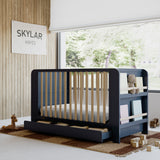 Read-with-me midnight blue with driftwood crib in nursery by window
